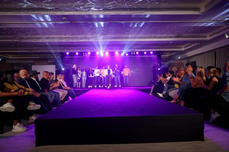 Fashion show finale under purple stage lights
