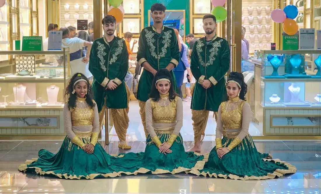 Garba dancers in green and gold at a mall activation