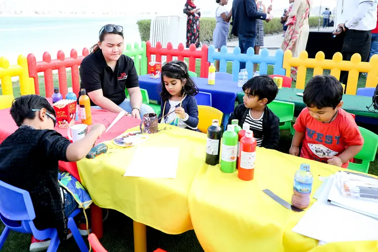 Kids painting at a family day activity table