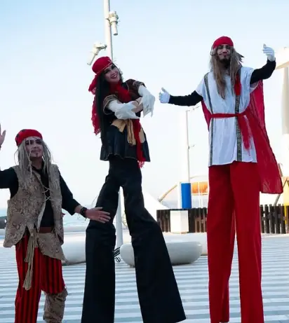 Pirate-themed stilt walkers greeting guests