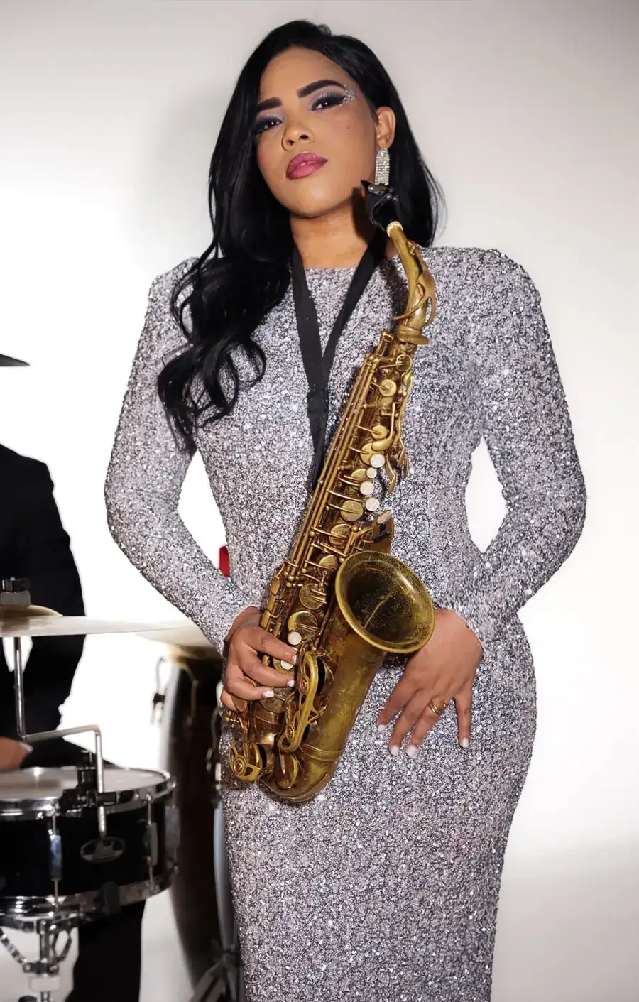 Saxophonist in a silver gown performing with a band