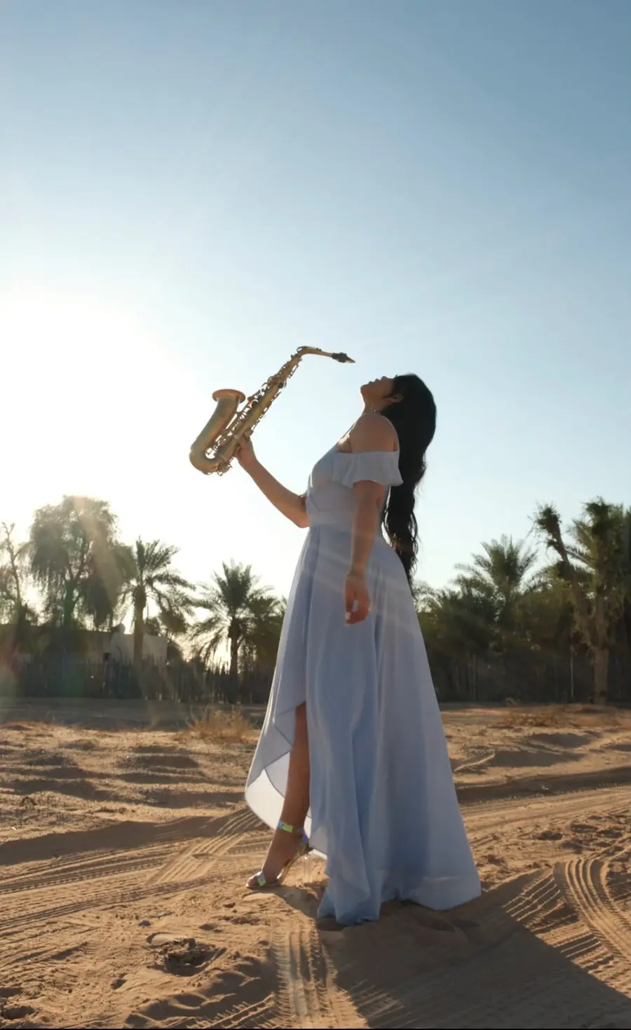 Saxophonist playing at a desert sunset setting