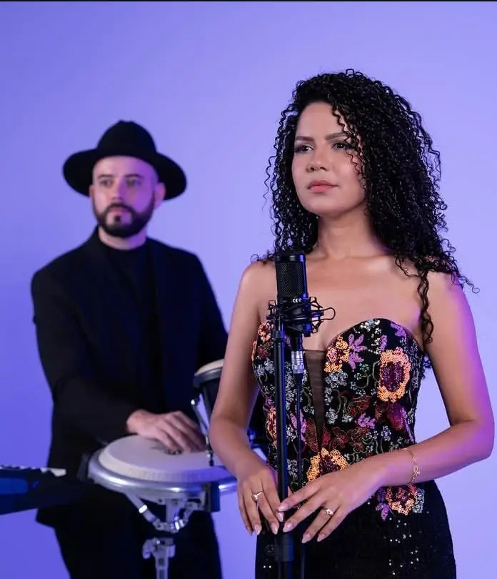 Singer and percussionist duo performing at an event